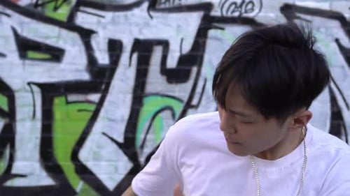 Male Dancer Performing in Front of Graffiti Wall