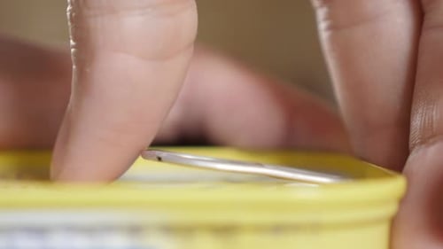 Sardine fish in oil can opening close-up of fingers and metal opener 4K 2160p 30fps UltraHD footage