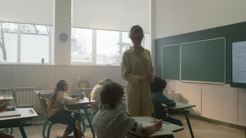 Teacher Supervising Students Working in Classroom