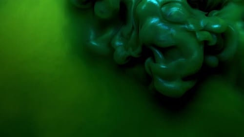 Colorful Green Ink Drops From Above Mixing in Water, Swirling Softly Underwater on Black Background