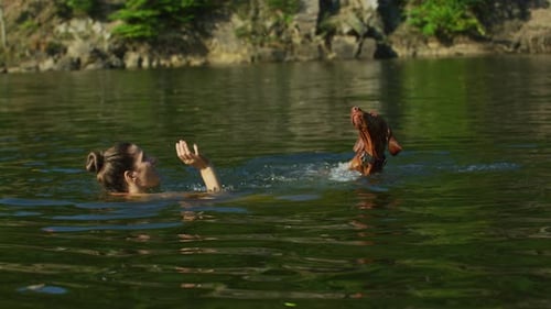 Woman and Dog Playing Fetch in Lake