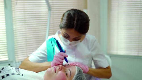 Cosmetologist Applying Permanent Make Up on Eyebrows