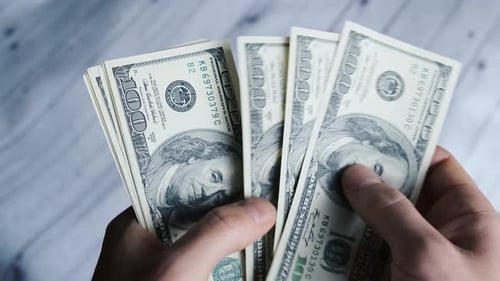 Männliche Person, die viele amerikanische 100-Dollar-Scheine zählt. Reicher Mann, der 100-Dollar-Banknoten zählt. Stich