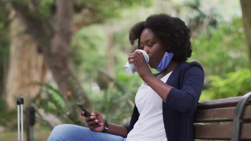 Mujer afroamericana con máscara facial en el parque
