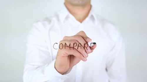 Hand Writes "Compare" on Glass Surface