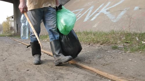 Person Picking Up Litter With a Stick