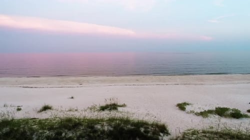 Les vagues longent la rive du golfe du Mexique au coucher du soleil sur l'île Saint-George, en Floride.