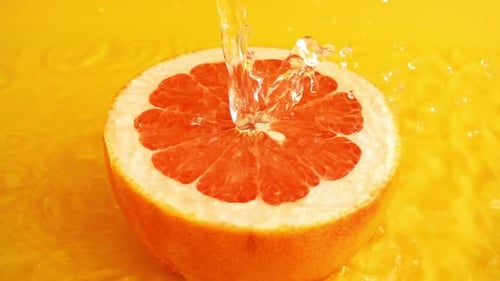 Water Pouring onto Cut Grapefruit in Studio