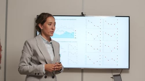Woman Presenting Business Data in Corporate Setting