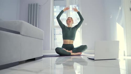 Blonde Woman Practicing Yoga at Home with Laptop