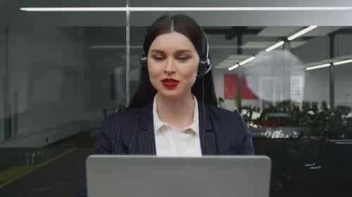 Woman Talking on Headset Working at Computer
