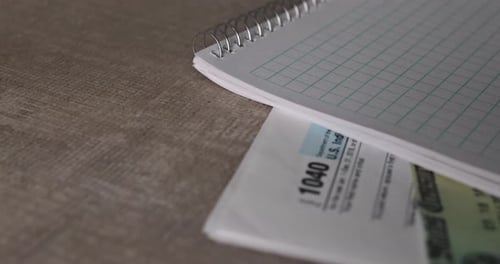 Tax Forms and Money on Table