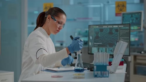 Woman Scientist Using Pipette in Modern Lab