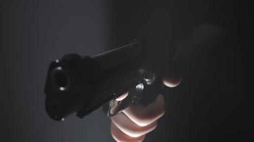 A hand holding a pistol that shots not bullets but a red flag with BANG! word