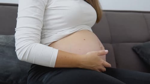 Pregnant Woman Holds and Touches Her Belly