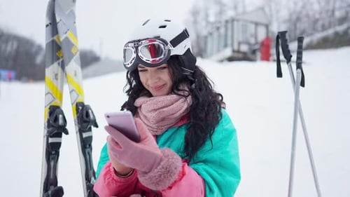 Young Caucasian Woman Surfing Internet on Smartphone Resting at Winter Resort