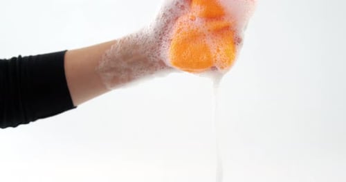 Close-up of hand squeezing cleaning sponge
