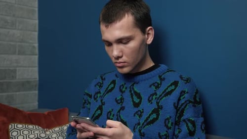 Young Adult Using Smartphone Indoors at Home