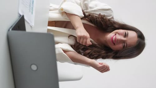 Excited Woman Dancing in Office Workspace