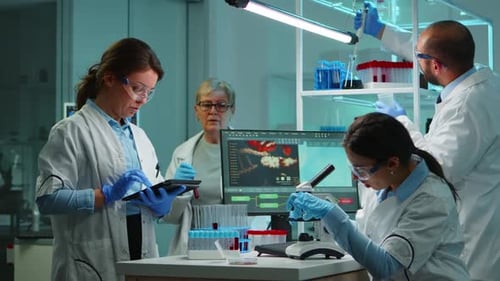 Une équipe de scientifiques en microbiologie discute du développement du virus