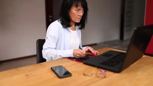 Woman Using Graphics Tablet with Laptop in Office