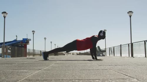 Man Exercising Doing Pushups on Waterfront Promenade