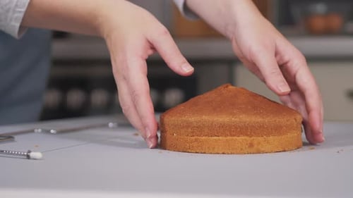 Der Konditor verwendet einen speziellen Cutter, um den gebackenen Kuchen in gleichmäßige Schichten zu schneiden