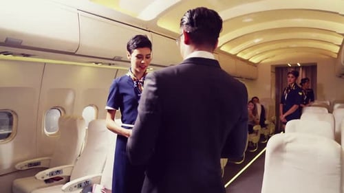 Cabin Crew Greeting Passenger in Airplane