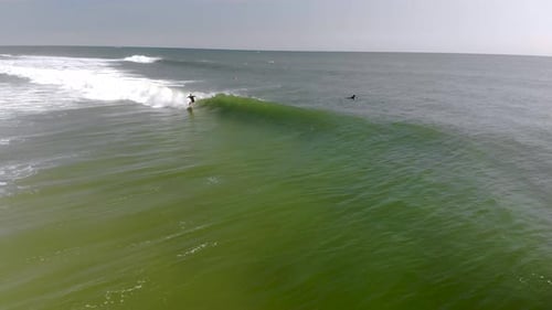 Epic drone tracking shot of surfer riding a wave.