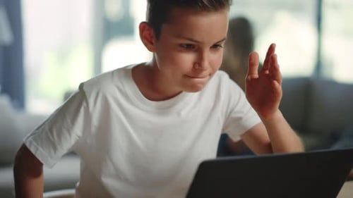 Enthusiastic Boy on Laptop at Home