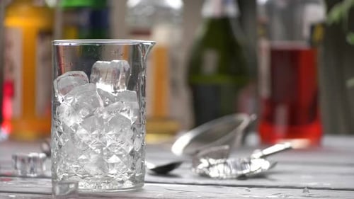 Making a cocktail with ice, jigger, and ingredients