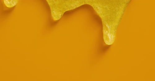 Close Up of Dripping Yellow Gel on Background
