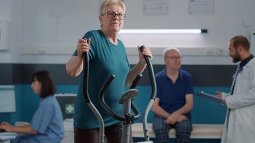 Senior Woman Using Elliptical in Physical Therapy