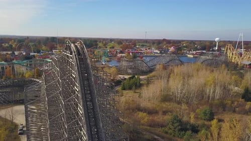 Aerial of rollercoasters and nature in sunlight at amusement park
