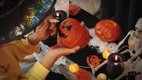 Painting scary pumpkin face for Halloween party.