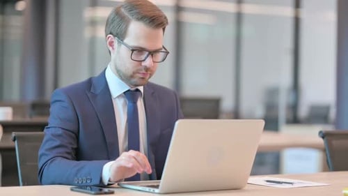 Businessman Celebrating Success While Working on Laptop