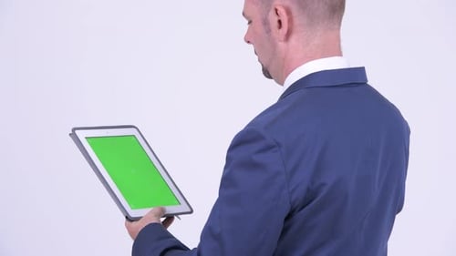 Vue arrière d'un homme d'affaires utilisant une tablette numérique