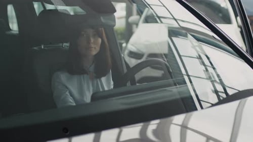 Bela jovem inspecionando o interior do carro na concessionária