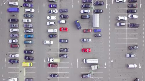 A bird's-eye view of parked cars in the parking lot near the shopping center.