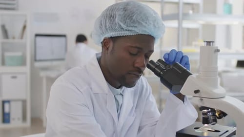 African Scientist Working with Microscope