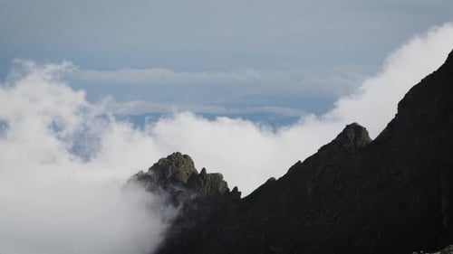 Majestic Mountain Peaks Surrounded by Swirling Clouds