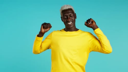 Man Dancing Energetically in Front of Blue Backdrop