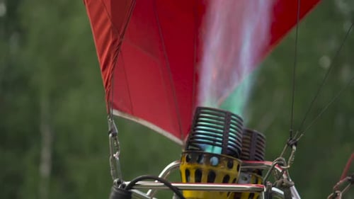 Close-up of hot air balloon burner inflating envelope, preparing for flight