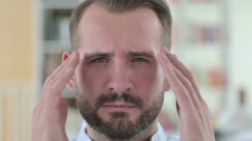 Close Up of Stressed Young Man with Headache