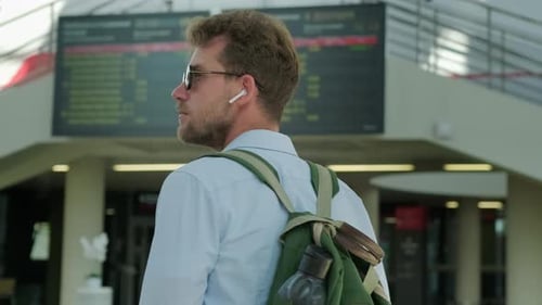 Traveller Is Examining Schedule of Departures and Arrivals in Airport