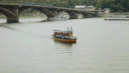 Passenger Ships in Blue and Yellow Colors and Personal Water Devices Pass the River Slow Motion Shot