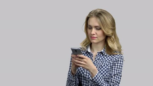 Woman Smiles While Using Smartphone