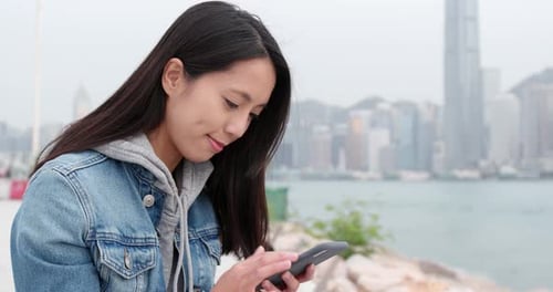 Young woman use of mobile phone at outdoor park