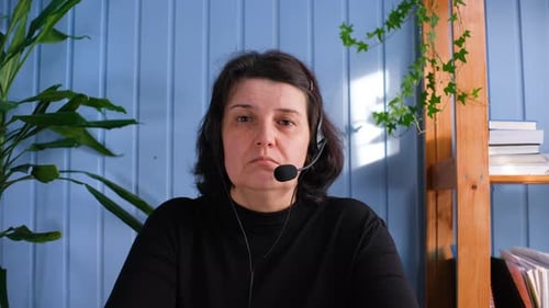 Woman At Desk With Headset And Plants