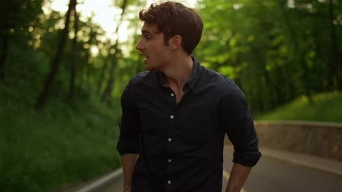 Handsome Man Spending Time Outdoors. Smiling Guy Having Walk in Park